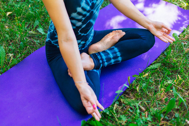 Young caucasian woman doing yoga exercises in summer city park. - Foto, Imagem