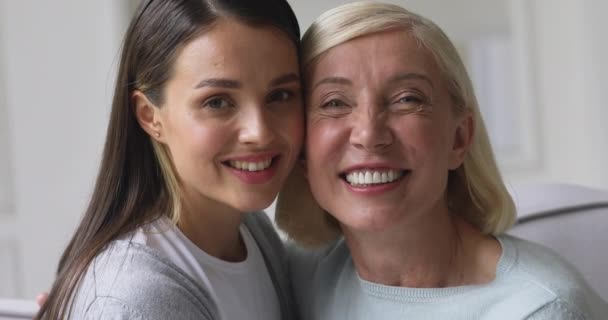 Happy young attractive woman looking at camera with older mommy. - Кадри, відео