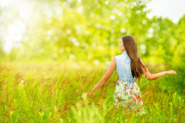 Vrouw in het veld achteraanzicht, Buitenleven in de natuur, Aantrekkelijk meisje in Summer Green Park Field - Foto, afbeelding