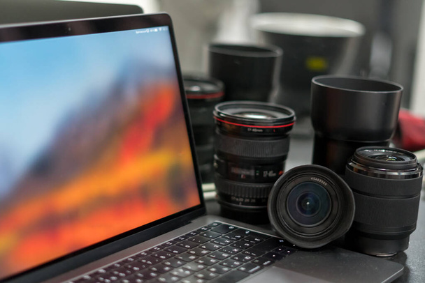 Digitale camera, lens en laptop. concept van een werkstation voor fotografen. Thuis werken. - Foto, afbeelding