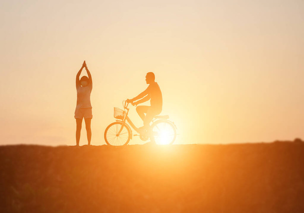 σιλουέτα του ζευγάρι οδήγηση ποδήλατο ευτυχισμένη ώρα ηλιοβασιλέματος - Φωτογραφία, εικόνα