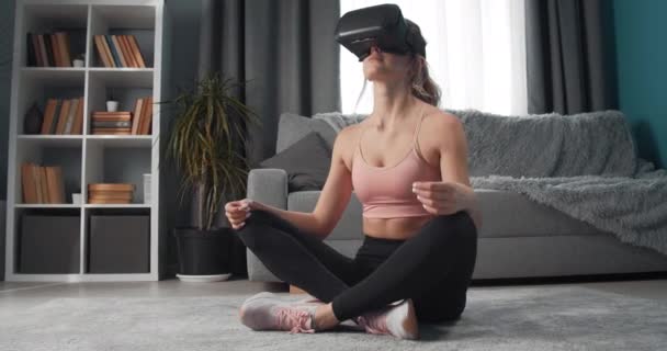 Young woman in virtual glasses relaxing in pose lotus - Felvétel, videó