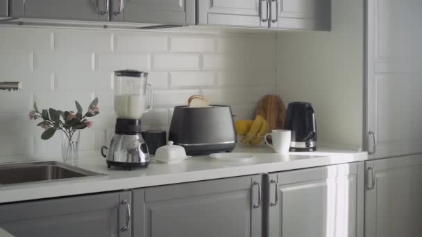 Порожня кухня з тостером, блендер з коктейлем, електричний чайник і скляна чаша з лимоном і бананом
 - Кадри, відео