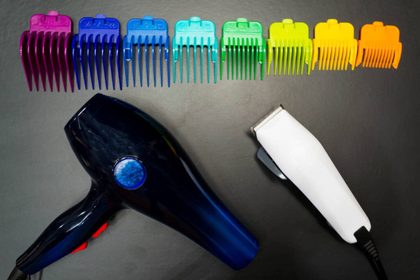 Stilvolle professionelle Friseurmaschinen zum Haarschneiden, Haarschneidemaschinen, mehrfarbige Düsen zum Haarschneiden, Zubehör für Haarschnitte auf schwarzem Hintergrund - Foto, Bild
