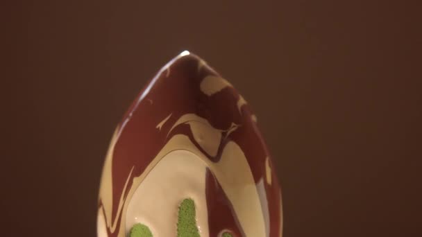 uma esponja em forma de ovo rolando e duas cores de fundação de contraste misturadas e derramando na esponja
 - Filmagem, Vídeo