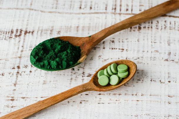 Spirulina powder and tablets in wooden spoon - Photo, image