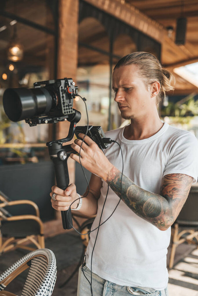 Professional man videographer with stabilizer gimball video slr - Fotó, kép