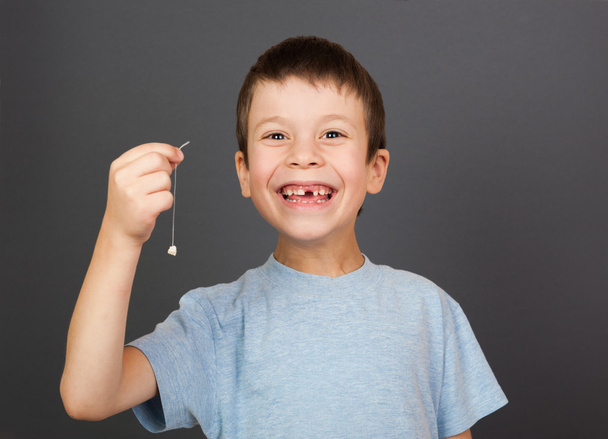 boy show lost tooth on a thread - Photo, Image