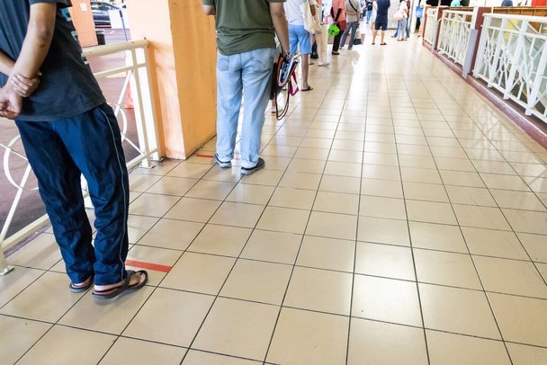 Nuovo stile di vita normale con distanza sociale in cui le persone sono separate da un divario di almeno 1 metro in coda nel supermercato in Malesia
 - Foto, immagini
