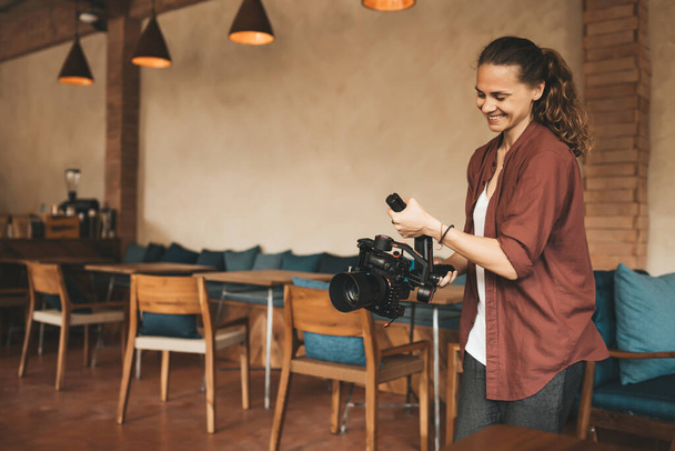 Professional woman videographer with stabilizer gimball video slr - Foto, afbeelding