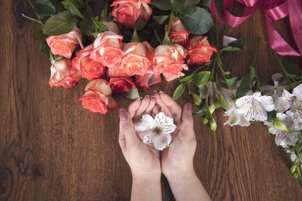 woman hand flowers on table background - Foto, Imagen