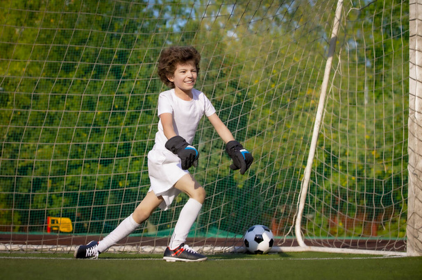 Summer soccer tournament for young kids. football club. emotions and joy of the game. Young goalie. Kids - soccer champion. Boy goalkeeper in football sportswear on stadium with ball. Sport concept. - Valokuva, kuva