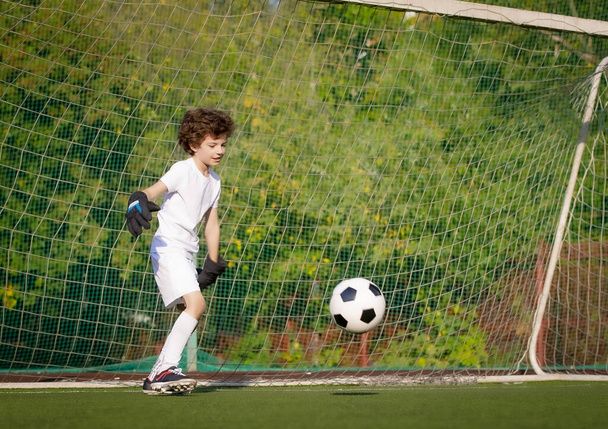 Summer soccer tournament for young kids. football club. emotions and joy of the game. Young goalie. Kids - soccer champion. Boy goalkeeper in football sportswear on stadium with ball. Sport concept. - Valokuva, kuva