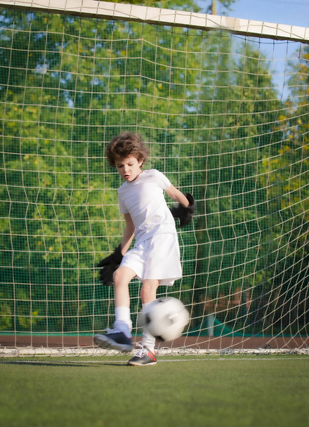 Summer soccer tournament for young kids. football club. emotions and joy of the game. Young goalie. Kids - soccer champion. Boy goalkeeper in football sportswear on stadium with ball. Sport concept. - Fotografie, Obrázek