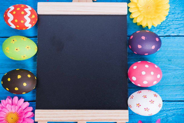 Easter eggs top view on blue wooden background and have board work space board for use - 写真・画像