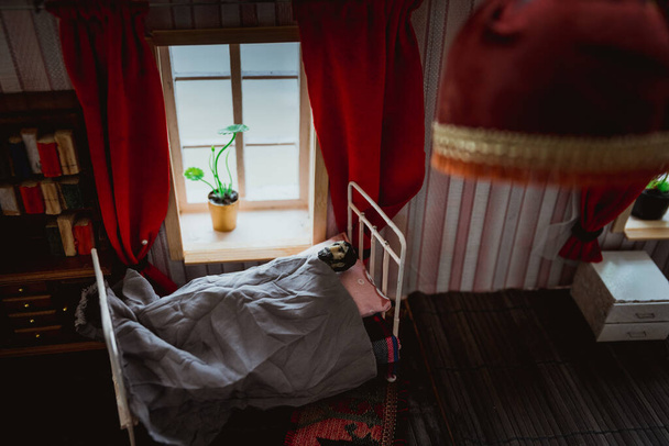 Hombre en la cama durante el día. Una casa de muñecas realista dormitorio con muebles y ventana. El virus Corona se queda en casa sea un concepto seguro. Enfoque selectivo
 - Foto, imagen