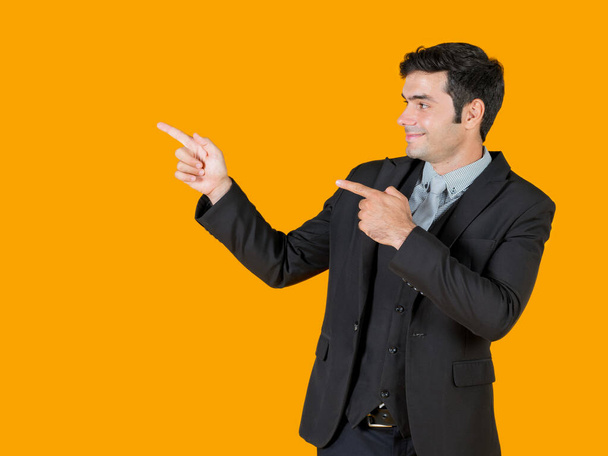 Un jeune homme d'affaires en chemise grise et un costume noir pointant les deux doigts dans la même direction. Affiche le projet qui est actuellement en plein essor. Le concept d'investissement dans une entreprise prospère
. - Photo, image