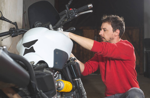 Mecánico reparador haciendo mantenimiento o reparación, fijación en la motocicleta, moto, centro de servicio
 - Foto, imagen