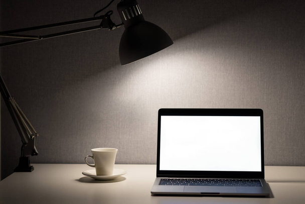 A laptop on the table. Freelance work from home. White screen with copy space. - Foto, Imagem