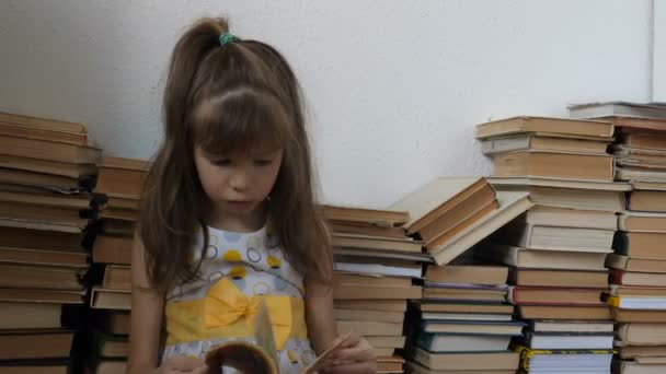 Μικρό κορίτσι διαβάζει βιβλίο στο πάτωμα - Πλάνα, βίντεο