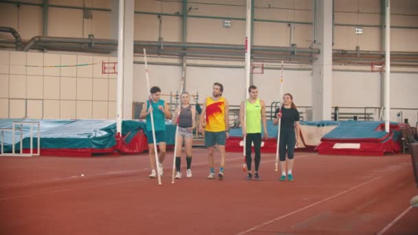 Grupa młodych uśmiechniętych ludzi na skoczni bieguna trening chodzenia po torze - Materiał filmowy, wideo