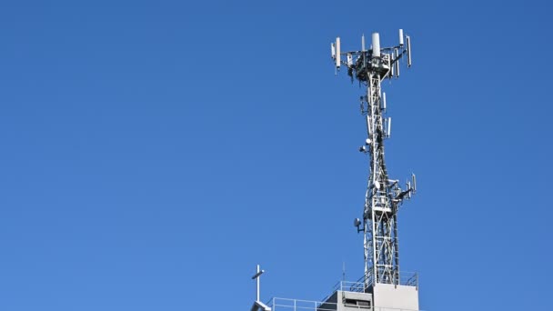 Beelden van cellulaire netwerkantenne op het dak van een gebouw. Zonnige dag, statisch frame. - Video