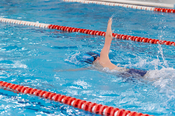 Entrenamiento de atleta de piscina en interiores para competición profesional. Adolescente nadador haciendo estilo libre - Foto, Imagen
