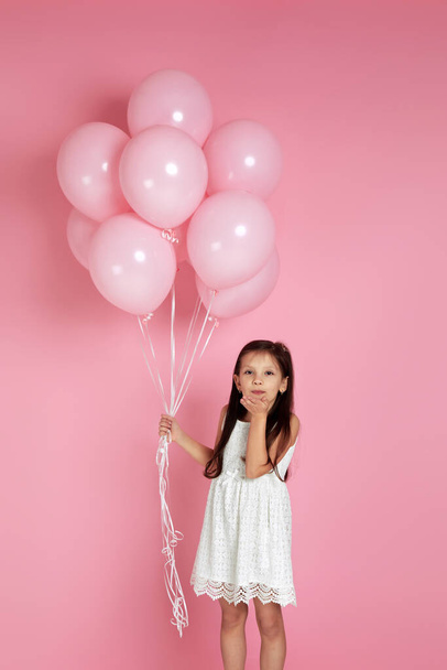 Smiling adorable little child girl with pastel pink air balloons - 写真・画像