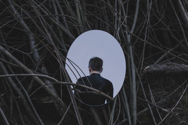 henkilö peilin edessä, jotka heijastavat hänen selkänsä, tumma käsite
 - Valokuva, kuva