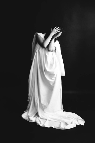 black and white studio portrait of a beautiful girl in a white sheet, beautiful female body, fashion and art - Фото, изображение