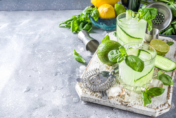 Огуречный базилик разбивает джин с водкой. Летний коктейль со свежими листьями базилика, цитрусовыми и огурцом
, - Фото, изображение