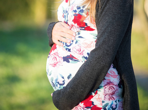 Nuori raskaana oleva nainen keväällä taustalla
 - Valokuva, kuva