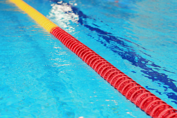 Χωρίζοντας την κόκκινη σημαδούρα στην πισίνα με καθαρό νερό - Φωτογραφία, εικόνα