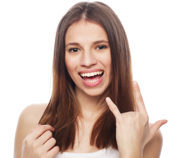 gelukkig vrouw poiting vinger omhoog op copyspace geïsoleerd op een wit - Foto, afbeelding