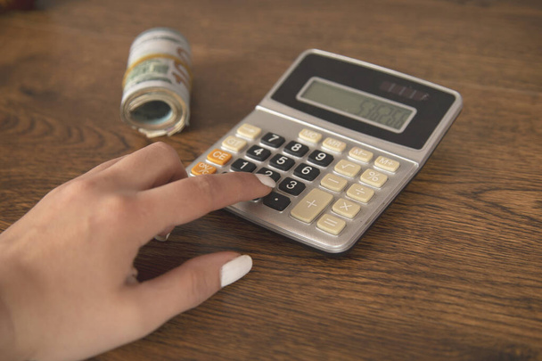 woman hand calculator and dollar on table - Φωτογραφία, εικόνα