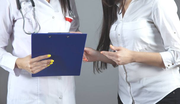 vrouw arts hand document en ziek op grijze achtergrond - Foto, afbeelding