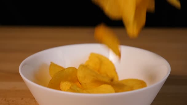 Potato chips falling into a plate - Záběry, video