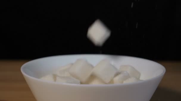 Cubos de azúcar cayendo en tazón
 - Metraje, vídeo