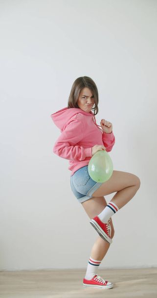 Young woman blowing balloon - Фото, изображение