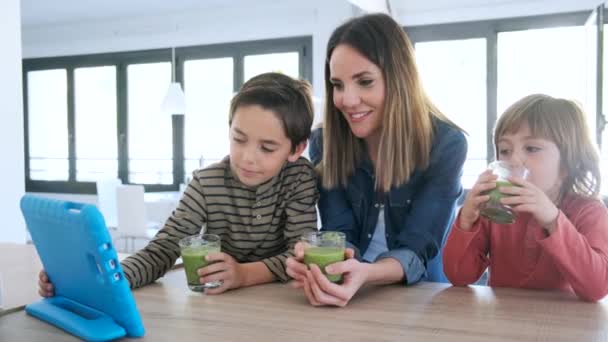Video of pretty mother with her sons drinking smoothie while using a digital tablet. - Séquence, vidéo