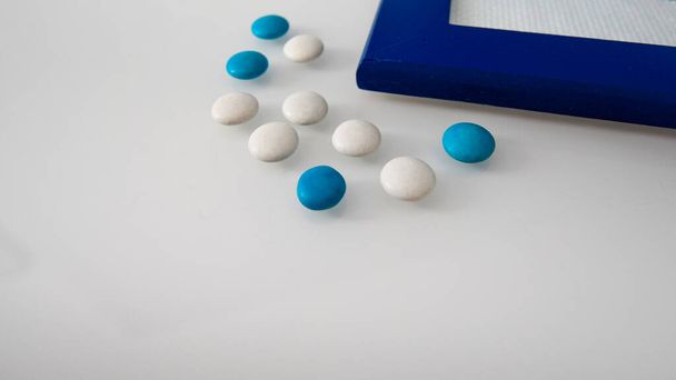 tablets or sweets, white and colored on a white table   - Foto, immagini