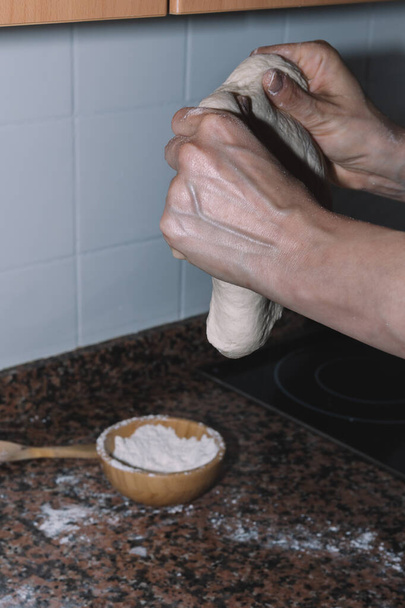 γυναίκα ζυμώνει ψωμί στο σπίτι κατά τη διάρκεια του εγκλεισμού - Φωτογραφία, εικόνα