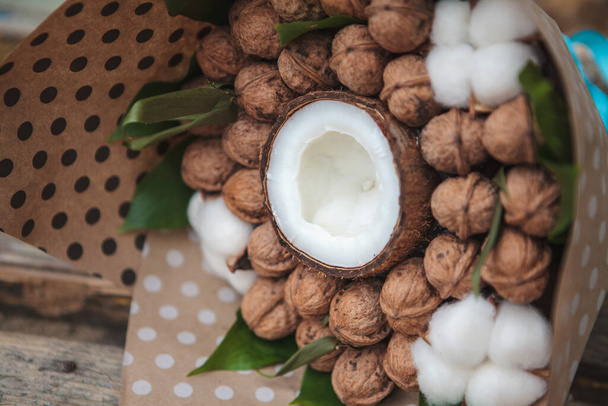 A bouquet of walnuts and coconut with natural cotton flowers. Edible bouquet. Close-up - Zdjęcie, obraz