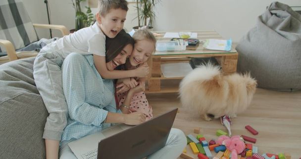 Glückliche Mutter und süße Kinder mit Laptop zu Hause - Foto, Bild