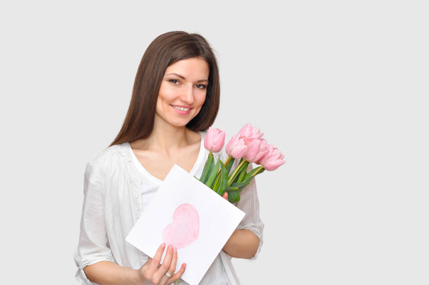Beautiful woman mommy smiling with flowers and gift.Mother 's day holiday
. - Фото, изображение