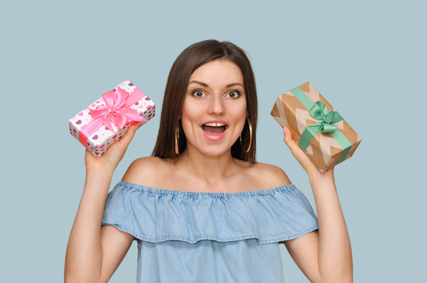 Belle femme sexy tient deux belles boîtes-cadeaux dans ses mains.Beaucoup de cadeaux, choix de cadeau. - Photo, image