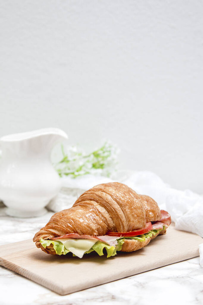 Sandwich Croissant auf Holztisch und Marmoroberfläche - Foto, Bild