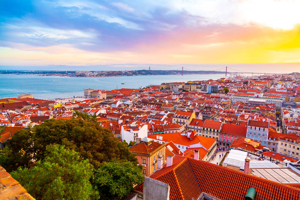 Beautiful panorama of old town Baixa district and Tagus River in Lisbon city during sunset, seen from Sao Jorge Castle hill, Portugal - Zdjęcie, obraz