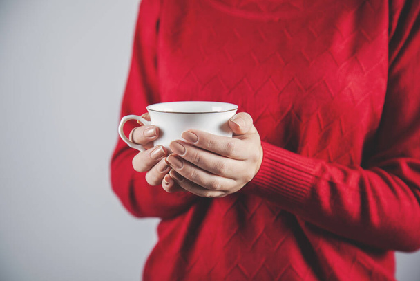 woman hand cup of coffee or tea on gray background - Zdjęcie, obraz