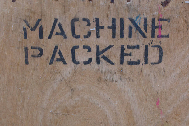 Wood panel with the words machine packed stencilled in black - Photo, Image